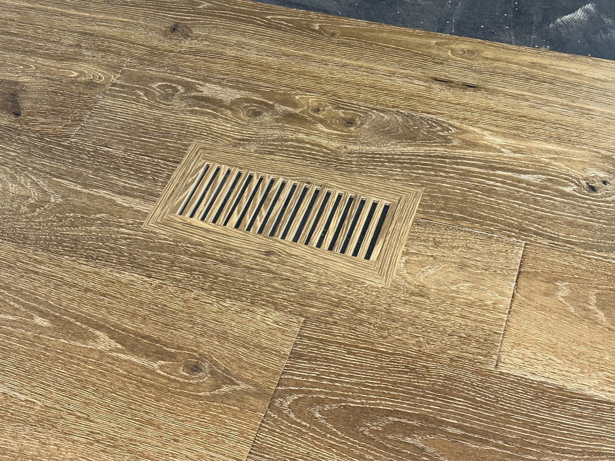 Custom wood floor vent covers perfectly matched to hardwood flooring, showcasing seamless integration with natural wood grain patterns